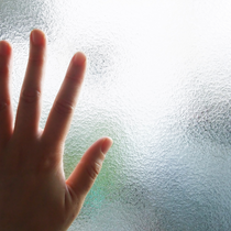 une main sur une vitre dépoli