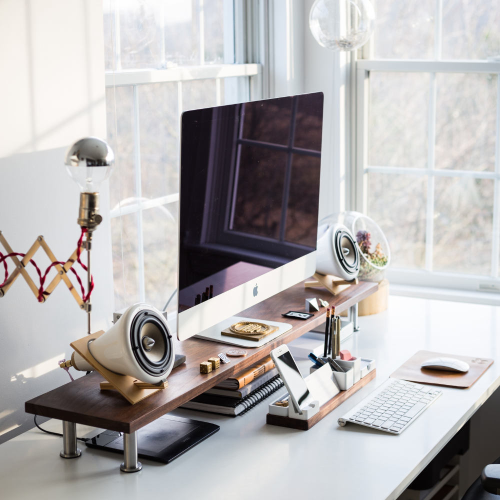 un bureau avec un ordinateur entouré de fenêtre